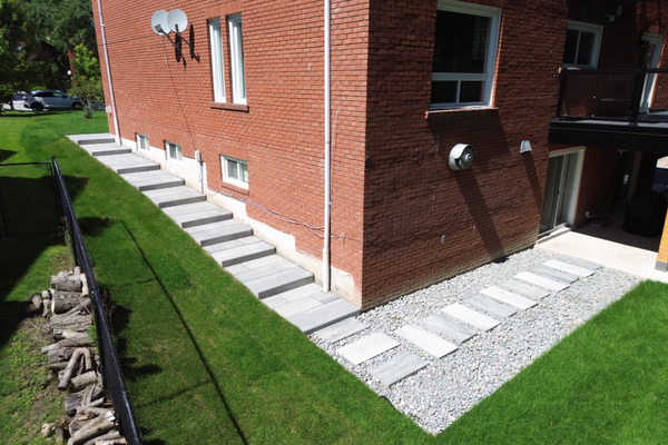 Interlocking steps installed on a sloped residential property with gravel stepping stone path in the GTA