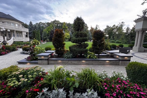 Mature trees and raised garden beds integrated into a professionally planned interlocking driveway in the GTA
